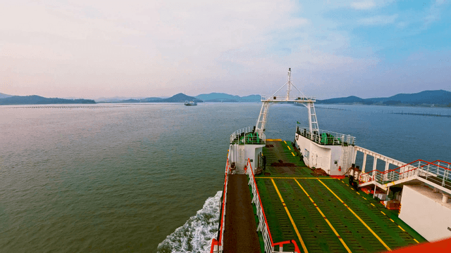 잔잔한 바다 위로 섬으로 항해하는 선박