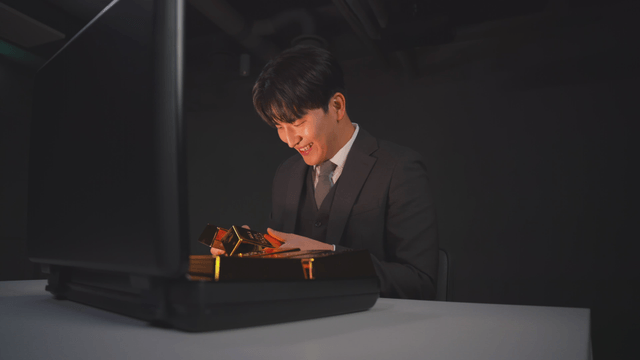 Man in suit opening briefcase with gold bars