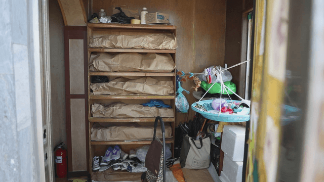 Shoe rack full of luggage in front of an ordinary entrance