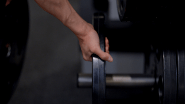 Man adjusting weights in a gym