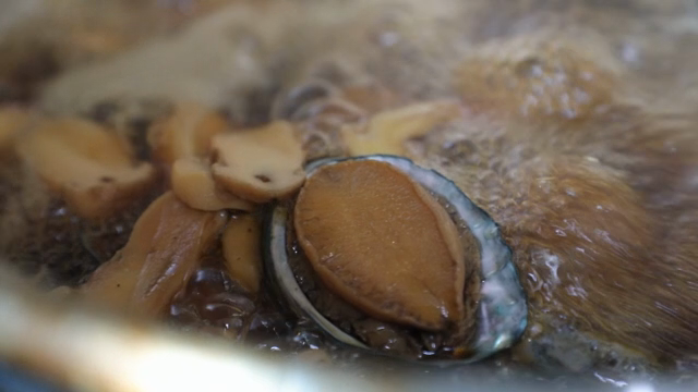 Abalone and mushrooms boiling in broth