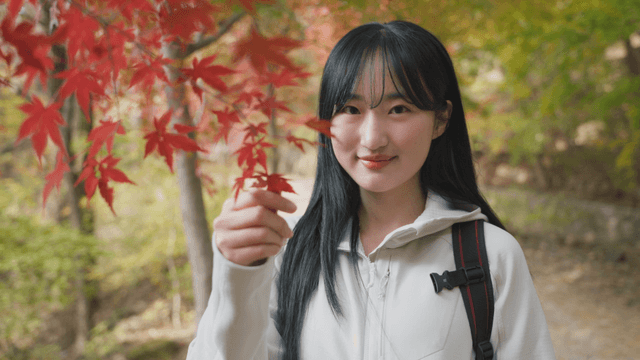 Young woman enjoying autumn foliage in forest