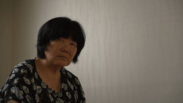 An elderly woman sitting indoors