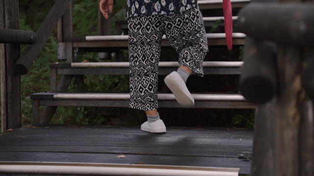An elderly person climbing outdoor stairs