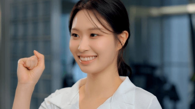 Smiling young woman cheering with a raised fist