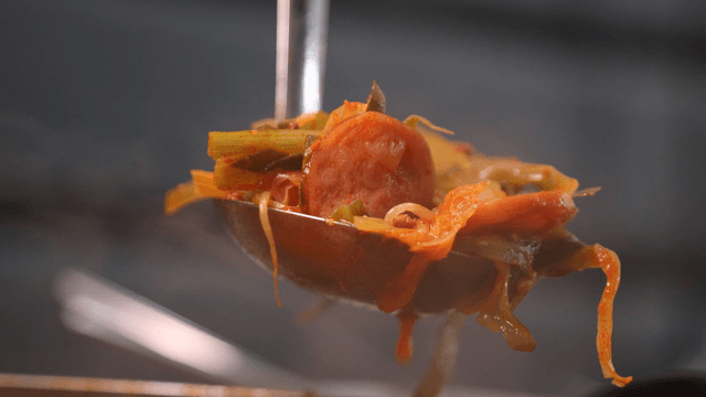 Ladle of budae jjigae with sausage