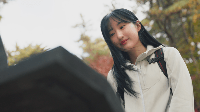 Young woman checking trail sign on autumn foliage path