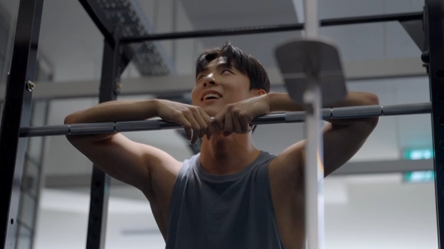 Man resting against barbell during workout