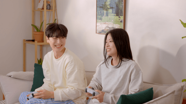 Couple playing console games on sofa
