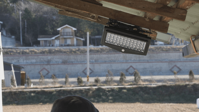 Person installing a light fixture under a roof