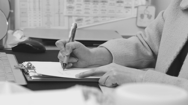 Person writing notes at a desk