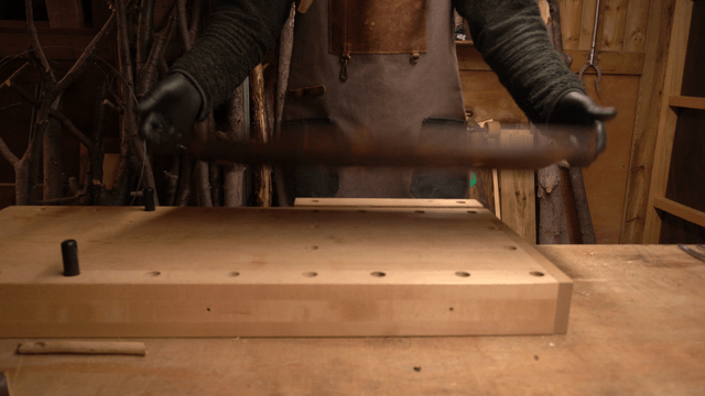 Artisan flipping a wooden board with metal handle