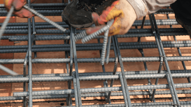 Worker assembling steel rebar on site