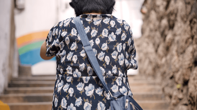 An elderly woman climbing outdoor stairs