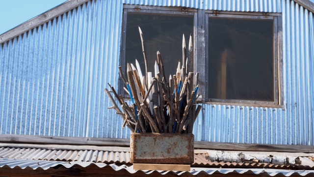 Wooden pencil sculpture placed on a roof