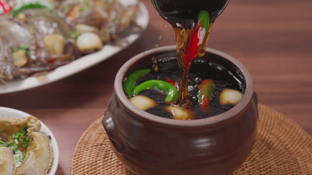 Jar filled with soy sauce marinade for crab