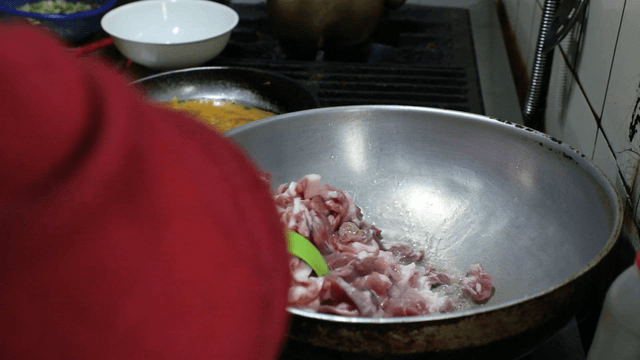 Cooking meat in a pan on a stove