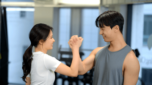 Couple encouraging each other while holding hands at gym