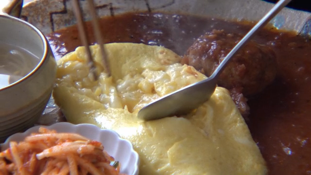 A fluffy omelette being sliced open