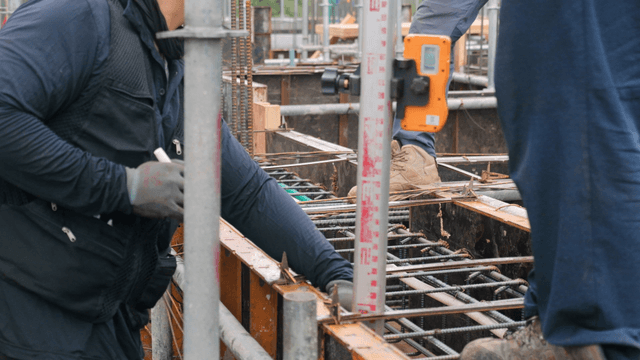 Workers measuring at a construction site