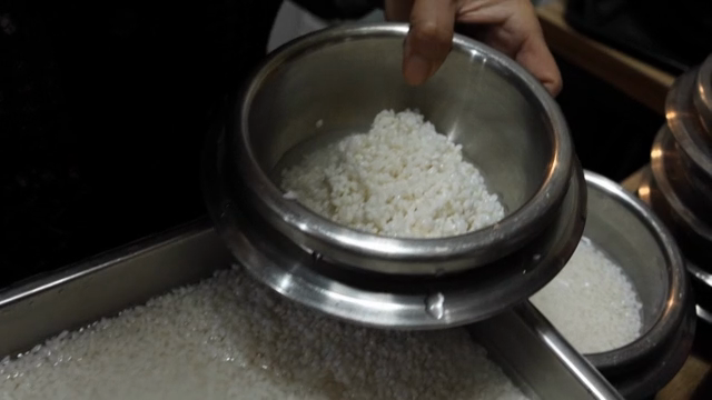 A scene of scooping rice into a pot