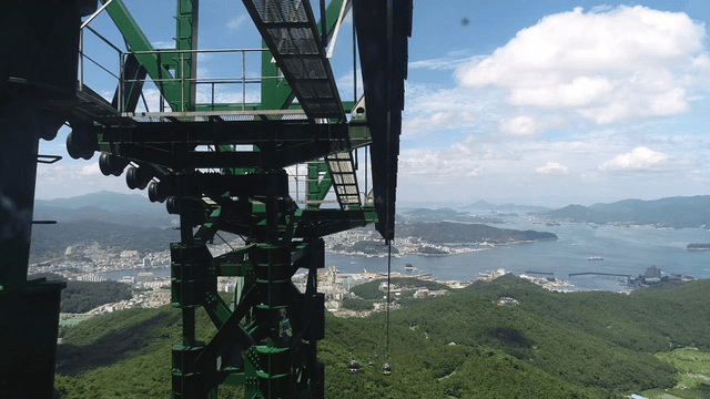 Cable cars over a scenic city and forest