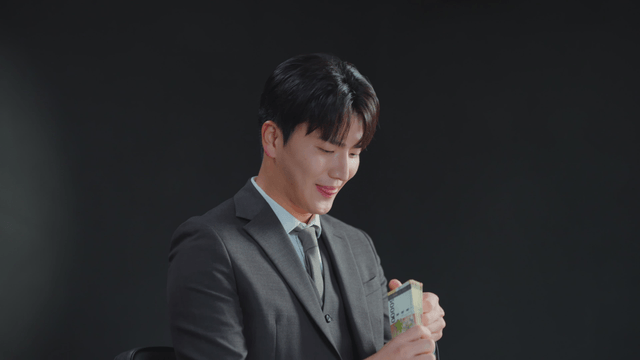 Man in a suit counting money with a smile