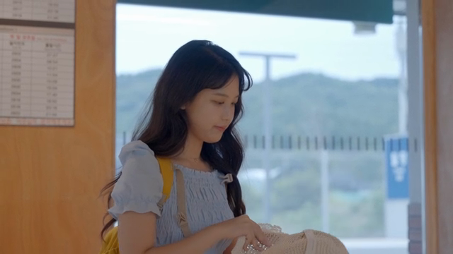 기차역에서 모자를 살펴보는 여성