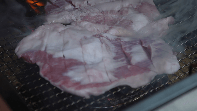 Whole pork jowl pre-grilled on a grill