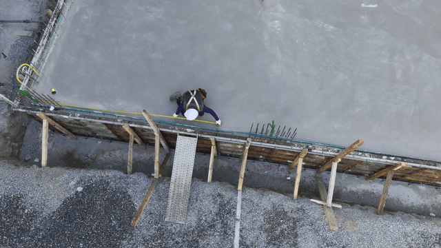 Worker measuring the length of concrete