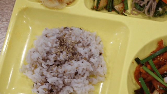 Various Korean dishes served on cafeteria tray