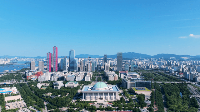 Aerial view of modern city skyline surrounded by parks and forests