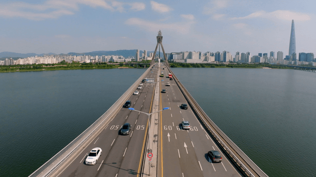 Bridge road over river with view of tall cityscape