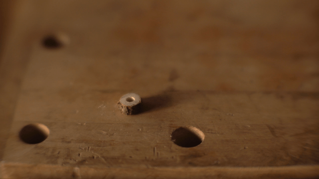 Gloved hand arranging wooden discs
