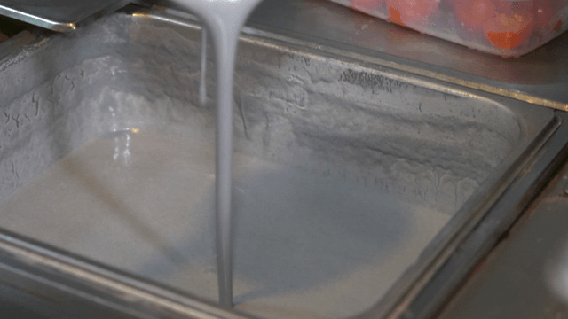 Ladle pouring thick black bean liquid