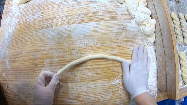 Hands shaping dough on a floured board