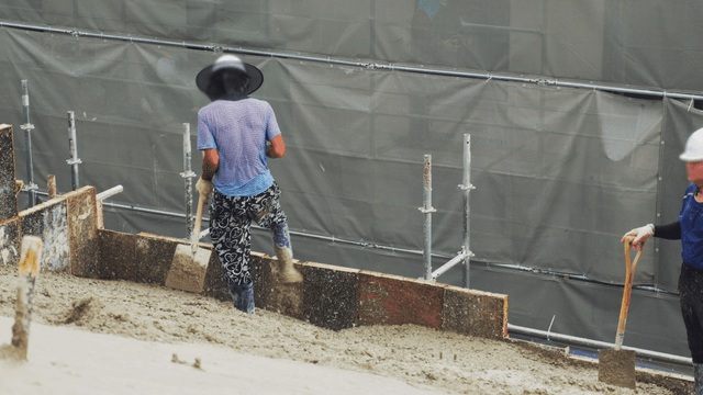 Construction workers leveling wet concrete
