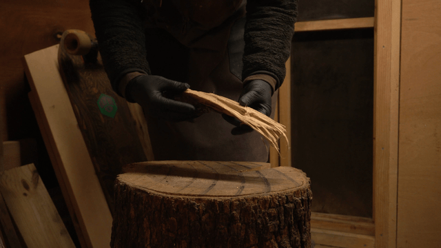 Woodcraft artisan preparing wood on a tree stump