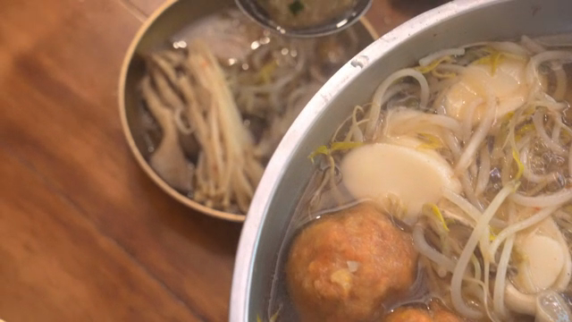 A scene of scooping dumplings out of hot pot