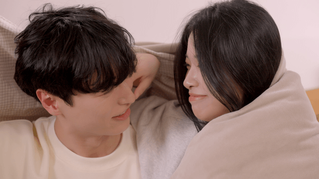 Couple smiling together under blanket