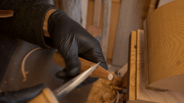 Woodcraft artisan carving wood delicately with a knife