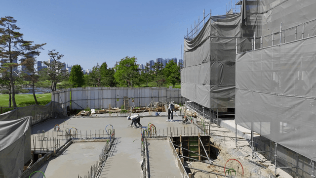 Workers smoothing concrete at a construction site