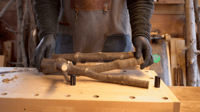 Artisan organizing wooden sticks on workbench