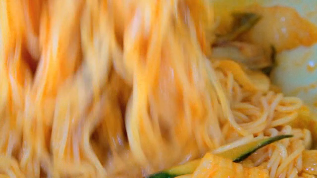 Mixing Korean spicy noodles in a bowl