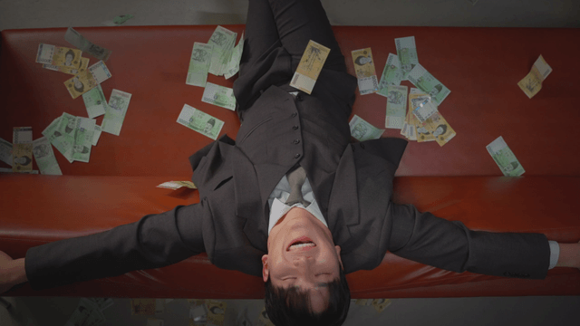 Cash raining down on a man sitting on a sofa