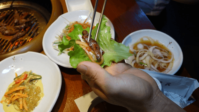 Seasoned grilled ribs and vegetable sides on lettuce