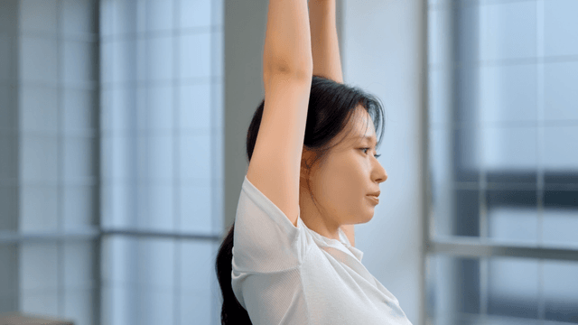 Young woman stretching indoors with focus
