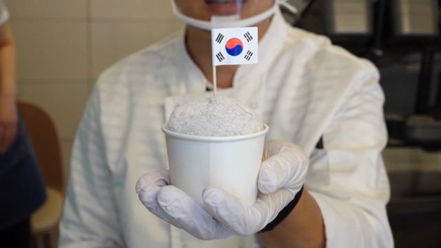Chef holding a dessert with a Korean flag