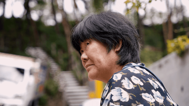 An elderly woman looking around