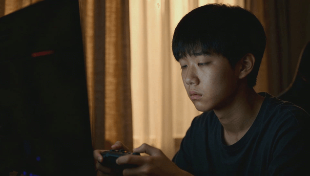 Teenager focused on playing a video game